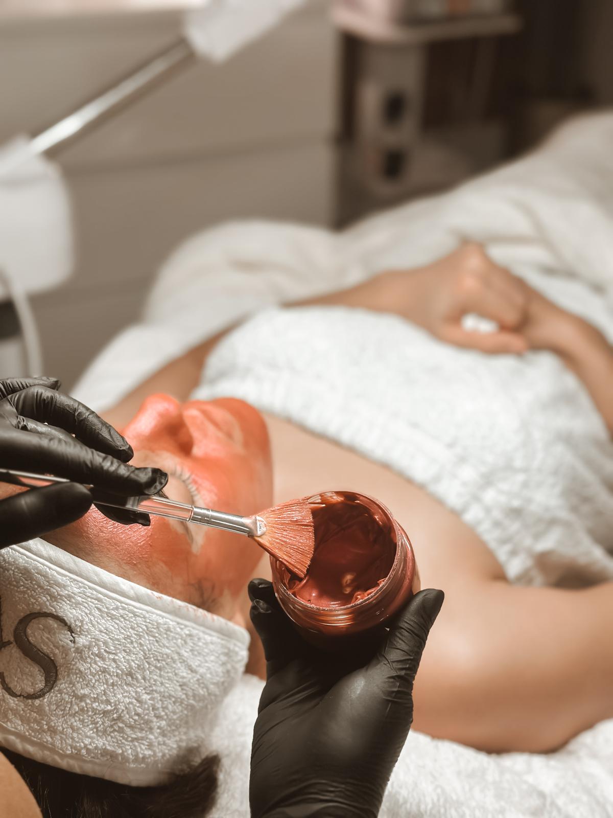Tratamento facial com máscara branca e aplicação de produto